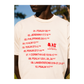 Person wearing a white t-shirt with red text and an Eat logo, outdoors.