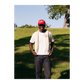 Person wearing a red cap with 'EAT' text, standing in a grassy outdoor area.
